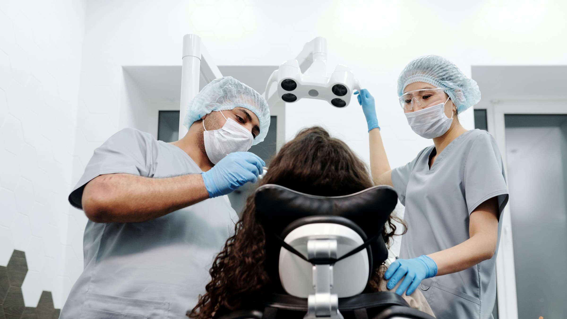 Dentist and dental assistant working together with a patient in a treatment room
